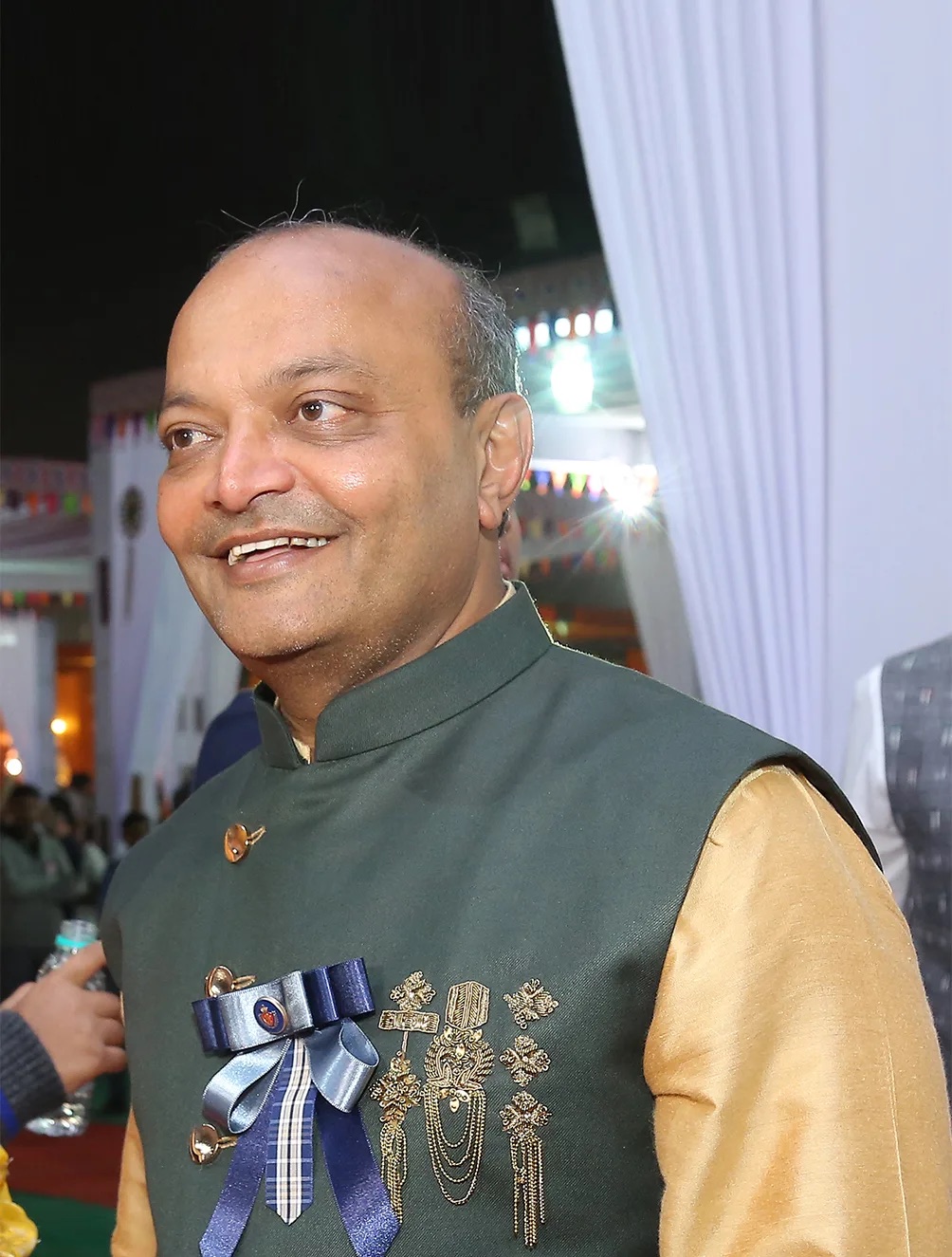 એક સાંજના ઉત્સવમાં લીલા બંધગલા જેકેટમાં સ્મિત કરતા મહેશ સવાણી