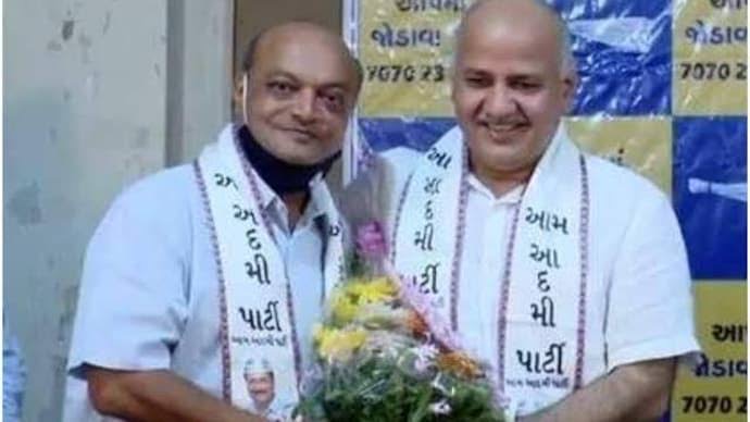 પુષ્પગુચ્છ હાથમાં લઈને ઊભેલા મહેશ સવાણી અને મનીષ સિસોદિયા